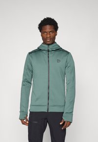 Kapuzensweatshirt mit Reißverschluss in sanftem Grün, mit schwarzen Akzenten, glatter Textur und Logo auf der Brust. Lange Ärmel mit Daumenlöchern.