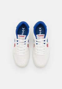 Weiße Sneakers mit blauen und roten Akzenten, aus glattem Leder, mit belüftetem Zehenbereich und Schnürdesign; markiertes Fußbett und Zunge.