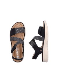 Svarta sandaler med grå vävda remmar, vadderad sula och beige sula. Justerbara stängningar förbättrar passform och stöd.