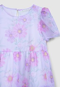 Robe lilas avec imprimé floral présentant des fleurs roses et blanches. Fabriquée en tissu transparent avec des manches bouffantes et une ouverture dans le dos.