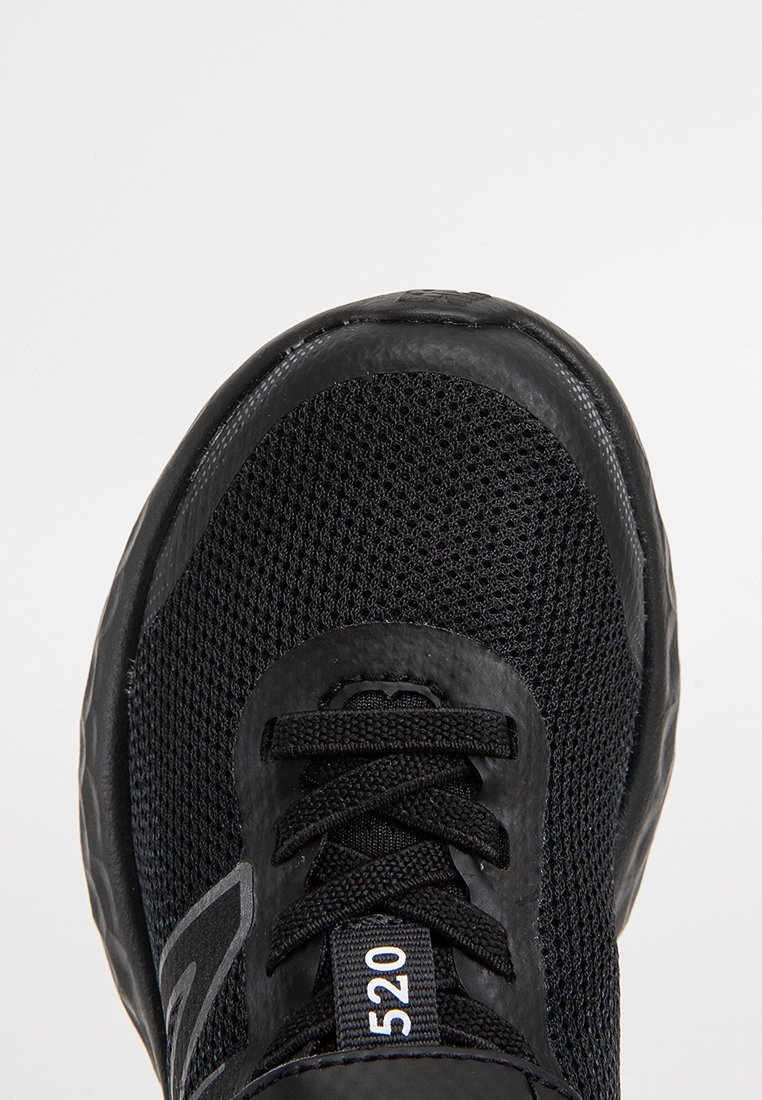 Baskets de course noires avec tige en mesh, lacets noirs et une étiquette à l'avant montrant le numéro "520" sur fond blanc.