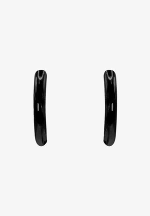 Boucles d'oreilles en céramique noires avec une finition brillante, présentant une forme ronde lisse et des courbes subtiles dans le design. Léger et minimaliste.