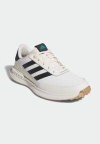 Vita sneakers med svarta ränder, texturerad överdrag och gummisula. Har en teal-accent på tungan och perforerade sektioner på sidorna.