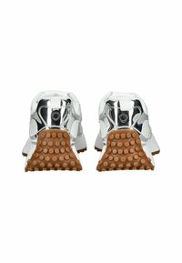 Zapatillas blancas con un diseño elegante, que cuentan con un talón metálico brillante, paneles texturizados y una suela de goma marrón con puntos elevados para un mejor agarre.