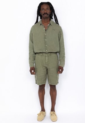 Olijfgroen shirt met knopen en borstborduursel, gecombineerd met bijpassende cargoshorts met zijzakken en een ontspannen pasvorm.