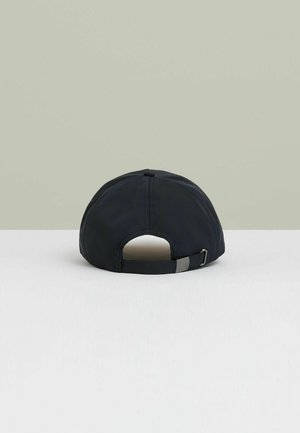 Marineblauwe baseballpet met een soepele stof, gebogen rand en een verstelbare strap aan de achterkant met een metalen accent.