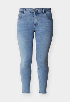 Jean skinny bleu clair avec bouton sur le devant, cinq poches et ourlets effilochés aux chevilles, présenté sur un fond blanc.