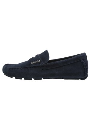 Donkerblauwe suède herenloafer met rubberen zool, mocassinnaaistijl bij de neus en Calvin Klein-logo op de band.