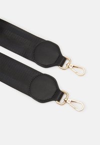 Sangle en tissu noir avec des accents en cuir et quincaillerie en métal doré. Caractérisée par un design large avec des extrémités arrondies et des clips en métal pour l'attache.