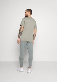 Nike Performance M NK DRY PANT HPR DRY LT YOGA - Calças de fato de treino - smoke grey/iron grey/black
