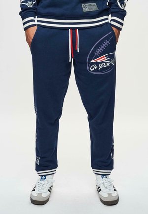 Marina sweatpants i bomullsblandning med vita och röda dragsnören, med en fotbollsgraphic och texten "Go Pats", ribbade muddar och logotypapplikationer.