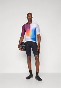 Koszulka kolarska z krótkim rękawem z gradientowym przejściem kolorów od fioletu przez niebieski do pomarańczowego, z przednim zamkiem; w zestawie z czarnymi spodenki.