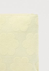 Ανοιχτό κίτρινο τσαντάκι με ανάγλυφο σχέδιο ανυψωμένων λουλουδιών, κατασκευασμένο από μαλακό ύφασμα με λείο φερμουάρ στο πάνω μέρος.