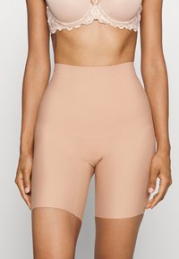 Beige høytlivsshorts laget av et glatt, elastisk materiale. Har en sømløs design og en lengde til midten av låret, perfekt for lag-på-lag styling.