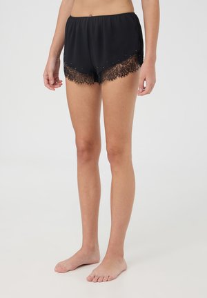 Shorts neri in satin con un bordo in pizzo trasparente e perline decorative all'orlo. Caratterizzati da un elastico in vita e una vestibilità ampia.