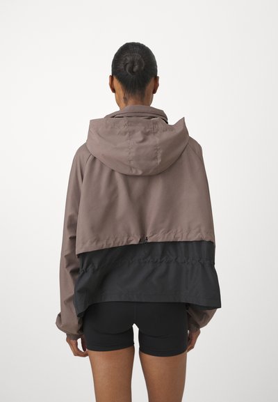 Braun und schwarze leichte Jacke mit Kapuze, taillierter Schnitt, elastischen Bündchen und Kordelzug am Saum. Glatte Textur und kontrastierendes Farbschema.