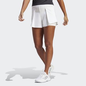 Hvide atletiske shorts med en plisseret design, der har en bred talje. Bæres med hvide sneakers, der viser lagdelt tekstur og struktur.
