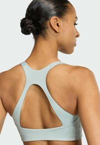  Lichtblauwe sportbeha met een racerback ontwerp. Vlotte textuur en uitsparingen op de rug. Minimalistische stijl, geen zichtbare hardware.