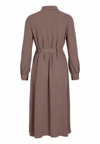 Dlouhé hnědé šaty z měkké tkaniny, s límečkem, dlouhými ruk�ávy se sklady na manžetách, páskem v pase a volně splývající sukní.