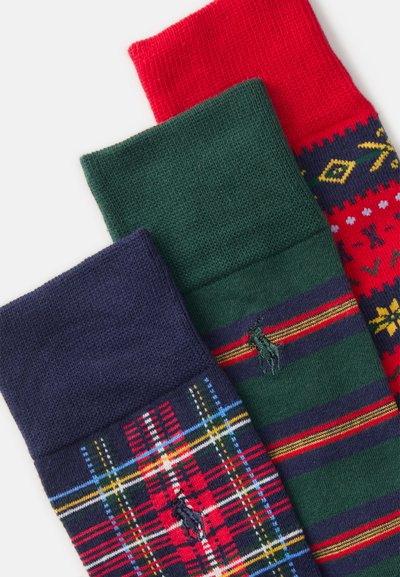 Tre paia di calzini: blu navy con motivo a quadri, verde con strisce orizzontali e logo, e rosso con un motivo festivo. Materiale a maglia testurizzato.