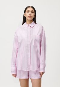 Camicetta a righe rosa con bottoni e maniche lunghe, dotata di tasca frontale, abbinata a pantaloni corti a righe rosa. Tessuto morbido, vestibilità comoda.
