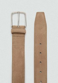 Suede belt in light beige with a polished silver buckle. Features five holes for adjustment and neat stitched edges. Smooth texture throughout.
