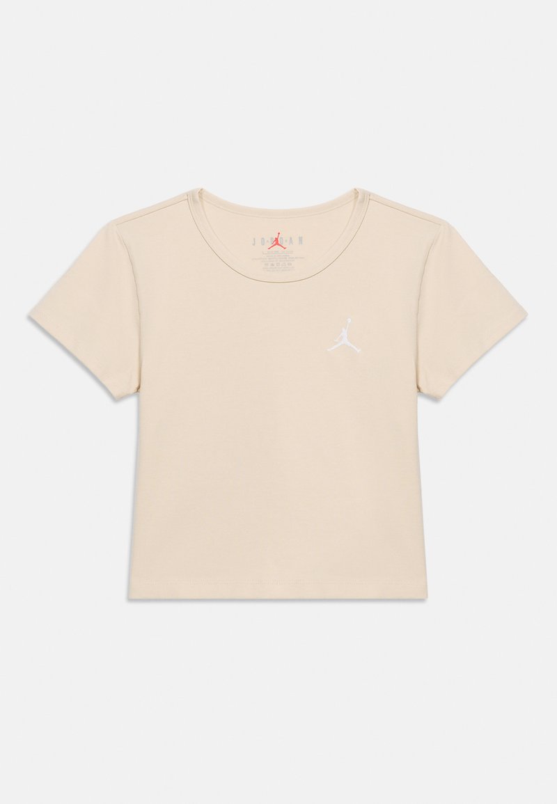 Μπεζ κοντομάνικο t-shirt Jordan με στρογγυλή λαιμόκοψη και λευκό λογότυπο Jumpman στο αριστερό στήθος, απλωμένο σε λευκό φόντο.