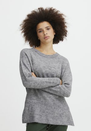 Pull en tricot gris avec une coupe décontractée, un col rond et un ourlet côtelé. Texture douce, manches longues et un dos légèrement plus long.