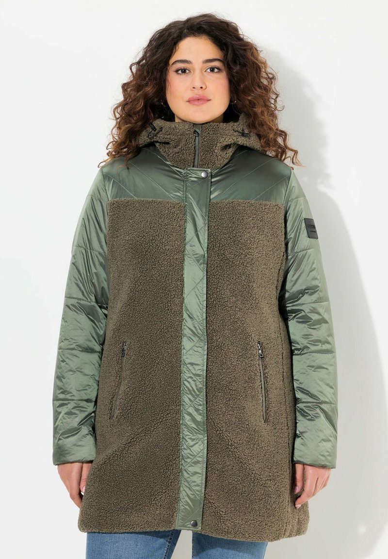 Olivgrön ytterklädsel med en kombination av mjuk fleece och glänsande tyg, med hög krage, dragkedjefickor och avslappnad passform.