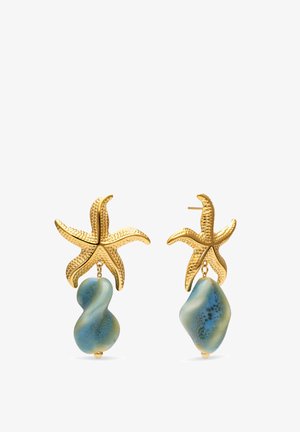 Pendientes dorados en forma de estrella de mar con superficie texturizada, cada uno con una piedra de color azul verdoso de forma irregular colgando debajo.