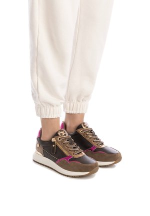 Zapatillas marrones y negras con acentos en rosa y dorado, que presentan un material superior texturizado, herrajes metálicos y una suela blanca.