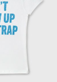 White short-sleeve shirt with blue worn-text style text partially visible reading "T W UP TRAP" on a light gray background.