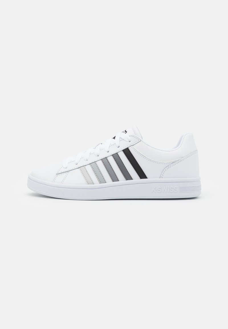 Valkoiset sneakerit, joissa on sileä nahkainen päällinen, ja joissa on kolme sävyttävää raitaa harmaana ja mustana sivuilla. Kauttaalta kumipohja ja nauhat.
