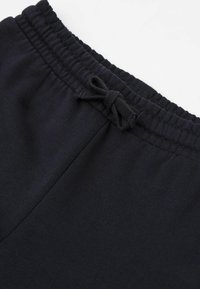 Schwarze Baumwoll-Jogginghosen mit elastischem Bund und Bindeband. Glatte Textur mit lockerer Passform, geeignet für Freizeitbekleidung.