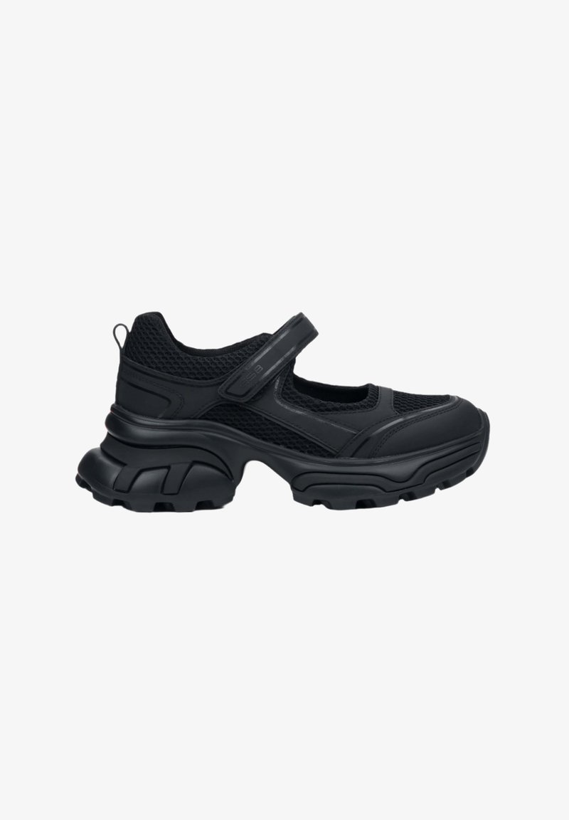 Black sneaker with a mesh upper and bulky rubber sole. Features a Velcro strap and rounded toe, suitable for casual wear.