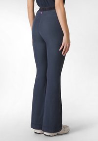 Námořnické zvonové kalhoty s černým elastickým pasem, na kterém je logo. Tkanina vypadá měkce a má hladkou strukturu, délka je ke kotníkům.