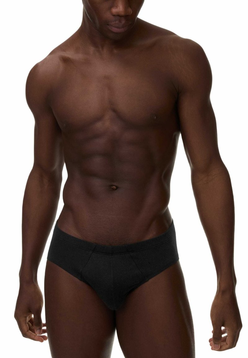 Schwarze Baumwollunterhose mit konturiertem Schnitt und elastischem Bund. Glatte Textur, minimale Nähte und keine sichtbaren Akzente oder Muster.