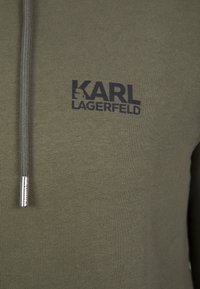 Tessuto a maglia verde oliva con logo nero "KARL LAGERFELD" e cordoncino abbinato con estremità in metallo sul cappuccio.