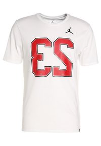 Vit bomullströja med korta ärmar, med stort rött och svart "ES"-tryck och en svart Air Jordan-logotyp på bröstet.