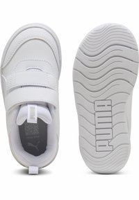 Baskets de sport blanches avec une tige en simili cuir, deux bandes Velcro, semelle en caoutchouc blanc texturé, et logo Puma visible sur le talon.