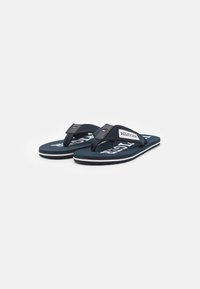 Marine flip-flops med en tekstureret rem, mærket med "HILFIGER." Hvid accent sål og slidbane giver greb og støtte.