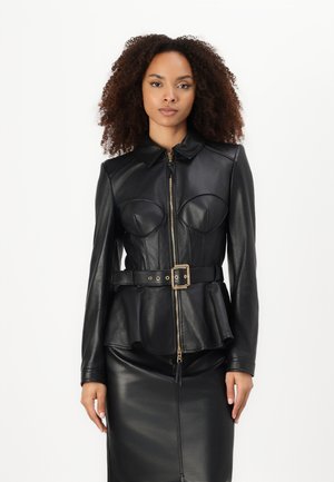 Giacca in pelle nera con design a peplo, dotata di zip frontale, colletto e due dettagli a forma di coppa sul petto. Accenti in metallo color oro.