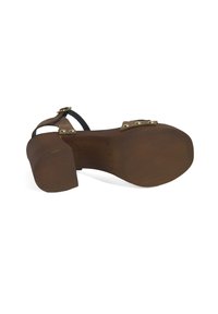 Bruine houten block-heeled sandaal met zwarte banden. Bevat messing accenten en een gestructureerde zool. Het ontwerp benadrukt comfort en ondersteuning.
