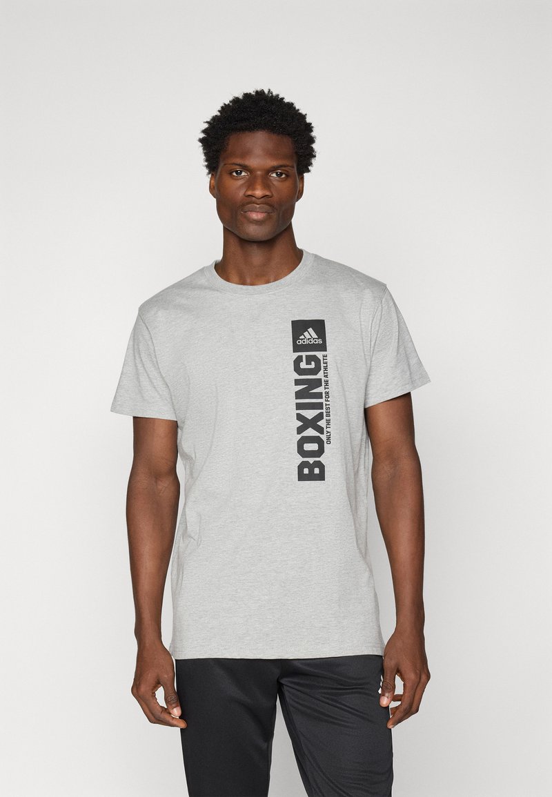 Grå bomull t-skjorte med svart "BOXING" tekst og Adidas-logo øverst til venstre. Korte ermer, rund halsdesign, og avslappet passform.