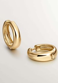Pendientes de aro de oro con un diseño suave y redondeado y un acabado brillante. La superficie interior presenta un patrón texturizado que realza el interés visual.