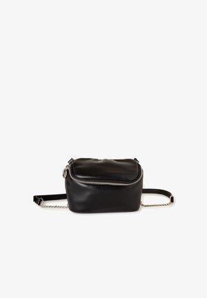 Zwarte leren crossbody tas met gebogen zilverkleurige ritssluiting en verstelbare riem met kettingaccenten, op witte achtergrond.