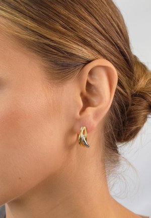Gold and silver metal earrings with an abstract design, featuring intertwining shapes and a polished finish.