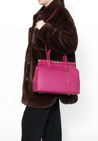 Borsa a mano in pelle rosa con un design strutturato, dotata di accessori in oro, doppie maniglie e una tracolla rimovibile. Superficie testurizzata e rivetti sulla parte inferiore.