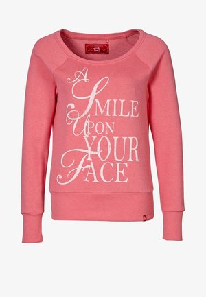 Roze sweatshirt met lange raglanmouwen, ronde hals en een afdruk van witte tekst met de tekst "EEN LAK MOOT JOUW GEZICHT." Zachte textuur.