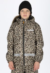 Wasserdichte Jacke mit Leopardenmuster und Kapuze, schwarzem Reißverschluss, reflektierenden Akzenten und elastischen Bündchen. Tragen über passenden Hosen.
